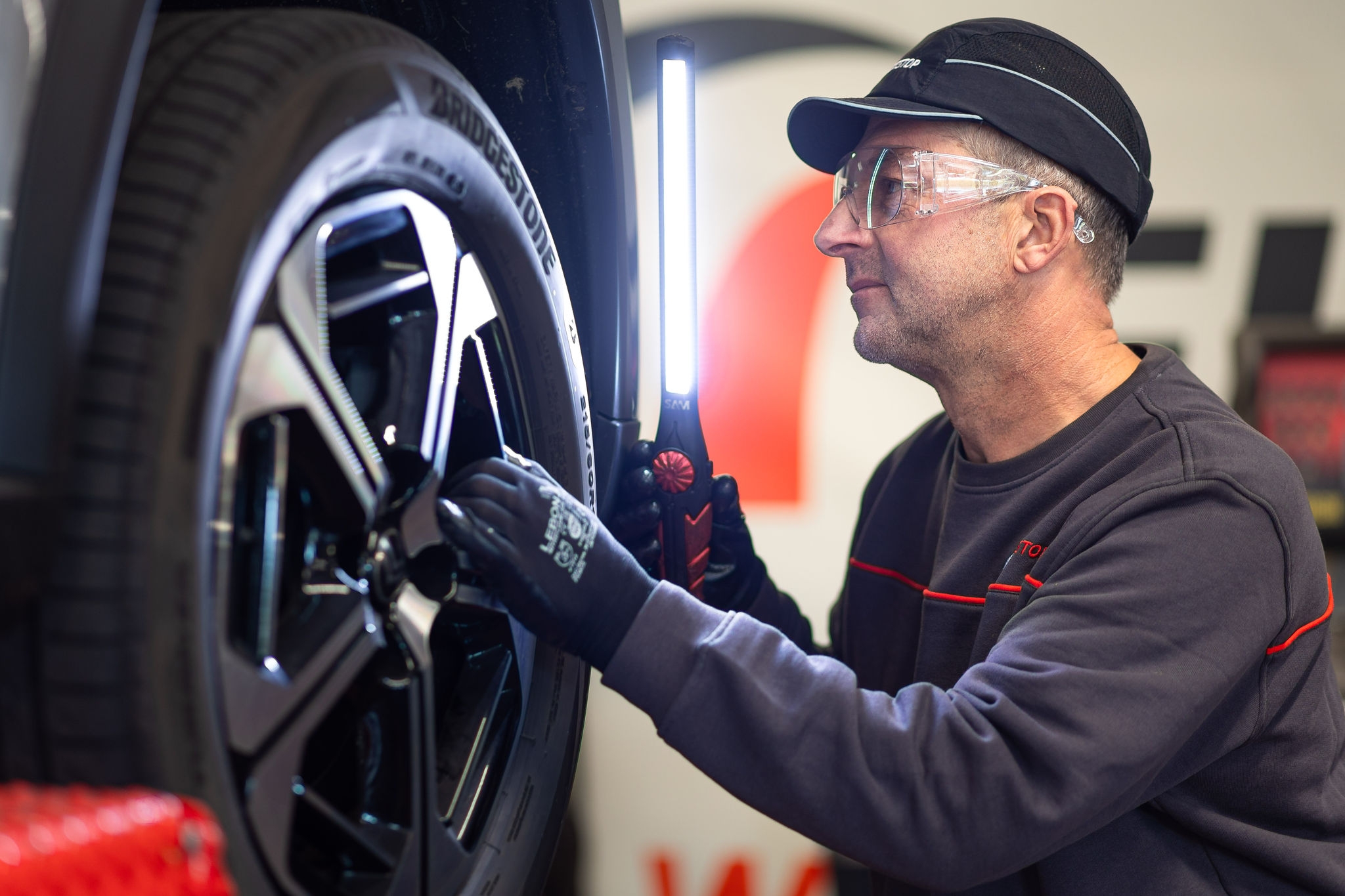 Mécanicien inspecte une roue avec lampe