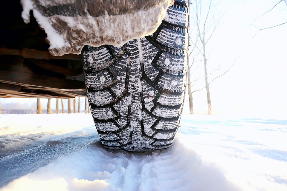 le pneu d'une voiture est recouvert de neige
