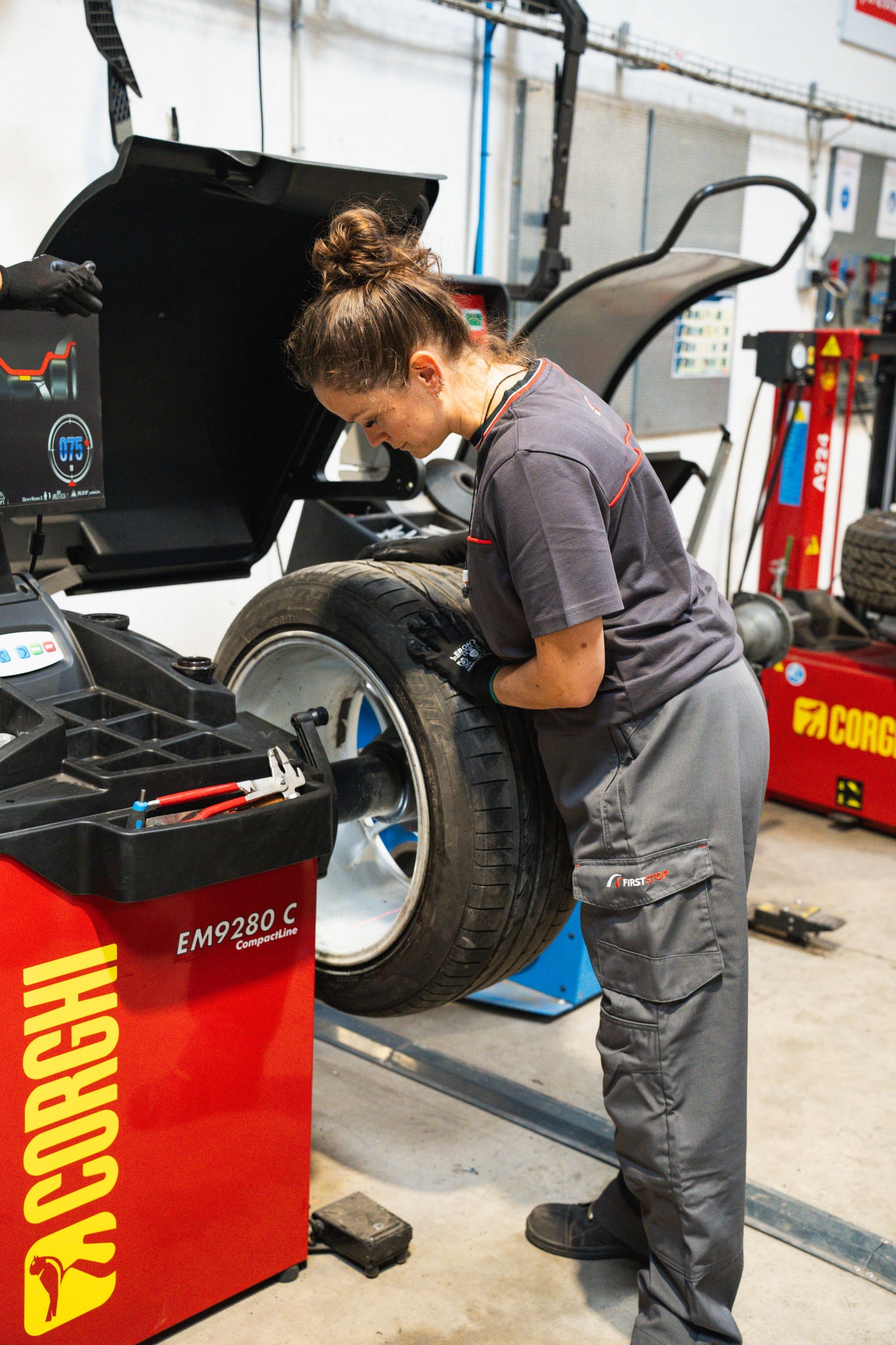 Mécanicienne équilibre un pneu en atelier