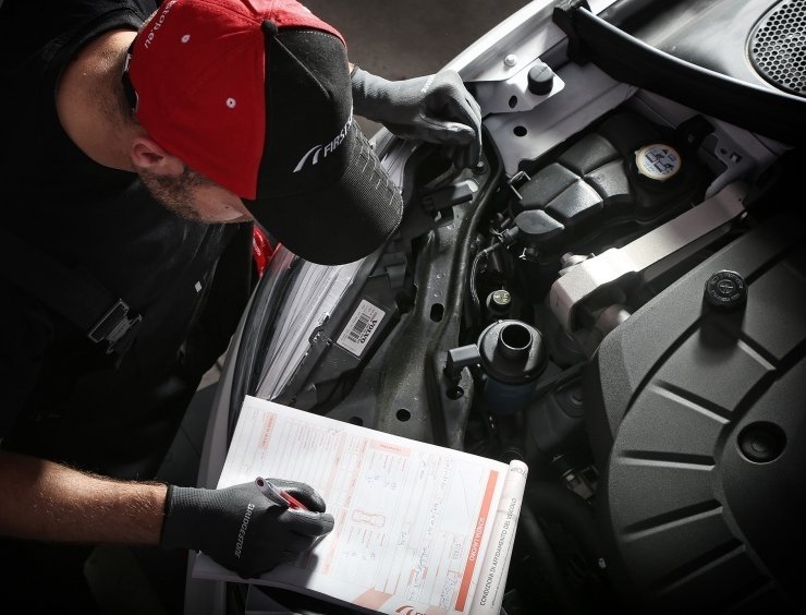un homme travaillant sur un moteur de voiture