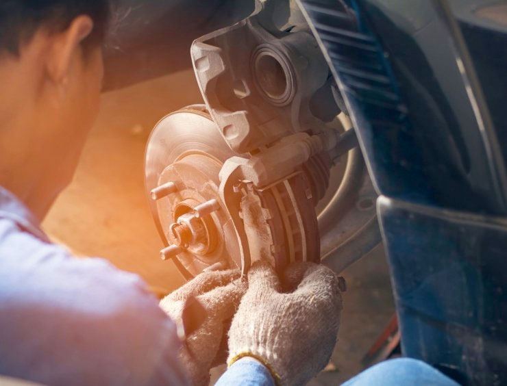 un homme travaillant sur la roue avant d'une voiture