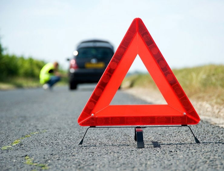 un panneau triangulaire rouge sur une route