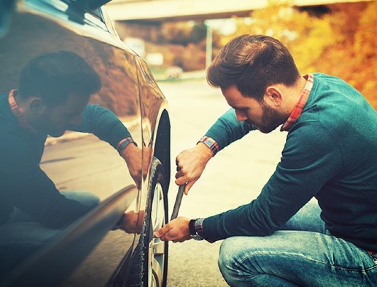 un homme qui répare le pneu d'une voiture 