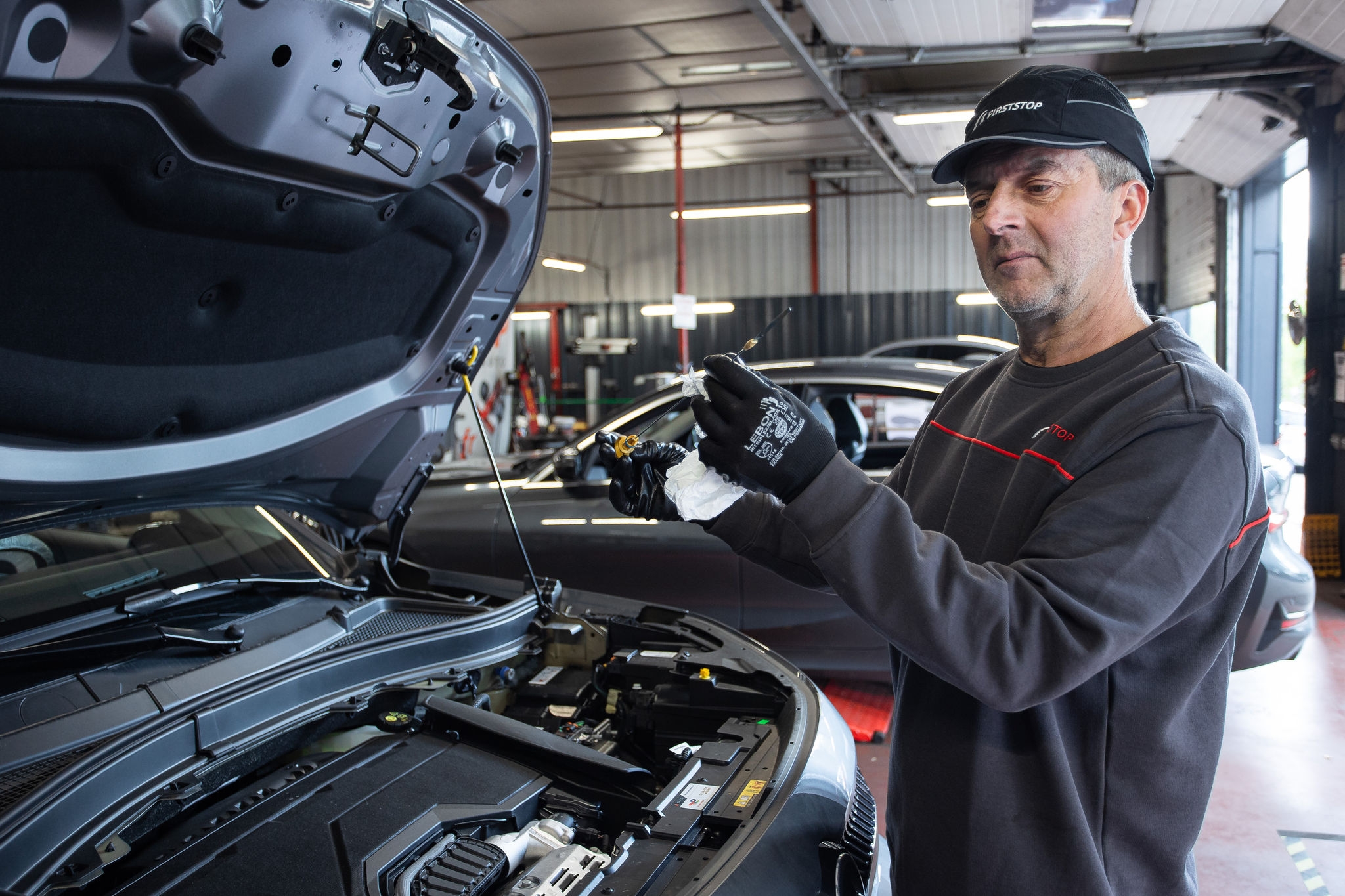 Mécanicien contrôle l’huile moteur en atelier