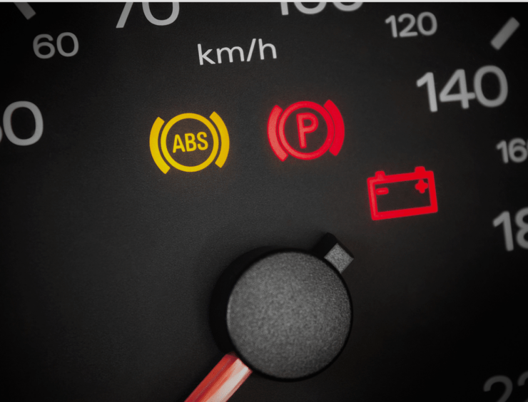 gros plan d'un indicateur de vitesse et d'une icône ABS sur une voiture.