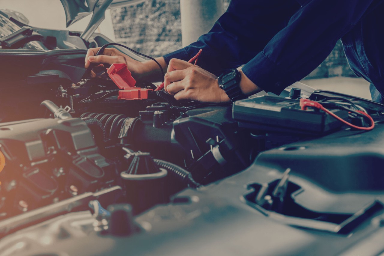 un homme travaillant sur un moteur de voiture