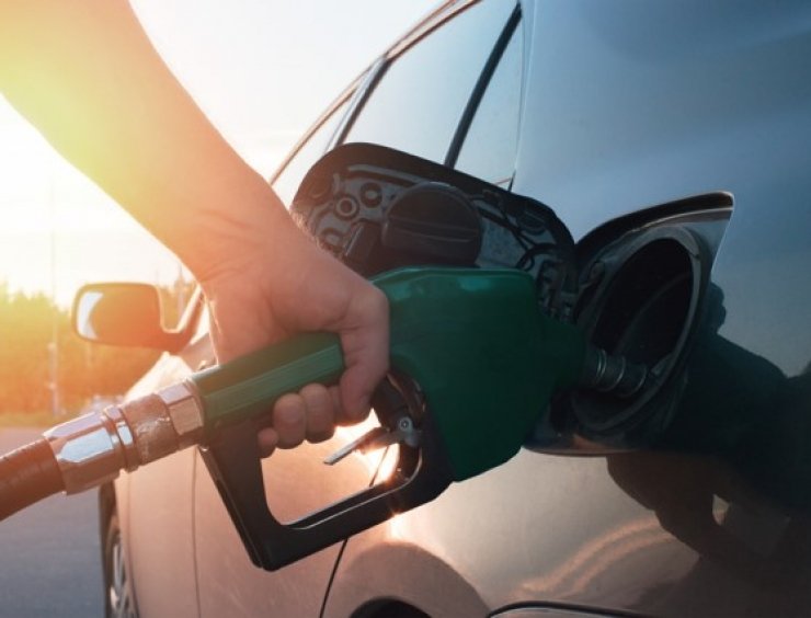 une personne qui met de l'essence dans une voiture dans une station-service