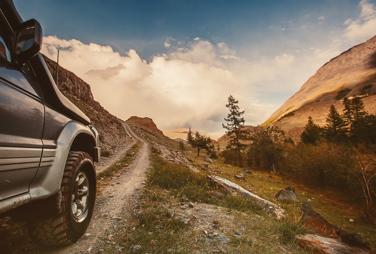une jeep descendant un chemin de terre dans les montagnes
