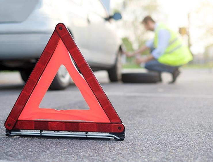 un panneau triangulaire rouge sur le bord d'une route